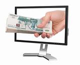 Hand with money and computer monitor