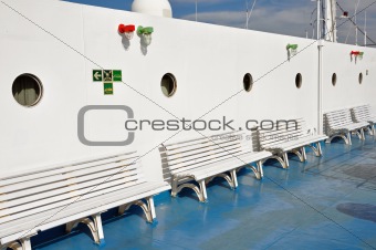 benches and portholes on ship deck
