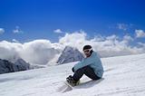 Snowboarder sitting on the snow