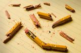 Broken pencil fragments on yellow paper