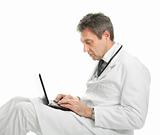 Medical doctor sitting and working on laptop