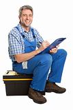 Confident service man sitting on toolbox