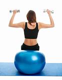 Fitness women doing weightlifting on fitness ball