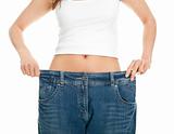 Slim woman pulling oversized jeans