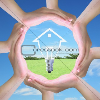 light bulb model of a house in women hand making a circle