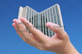 businessman hand holding a building