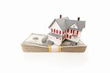 Small House on Stack of Hundred Dollar Bills Isolated on a White Background.