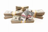 Small House with Stacks of Hundred Dollar Bills Isolated on a White Background.