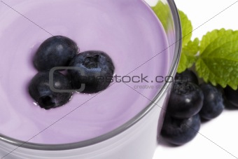 blueberries on top of a blueberry milkshake with blueberries aside