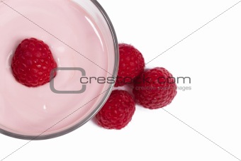 raspberry on top of a milkshake with raspberries aside from top