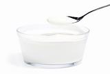 yogurt on a spoon over yogurt in a glass bowl