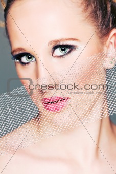 Portrait of fashion girl closing face with textile. Retouched

