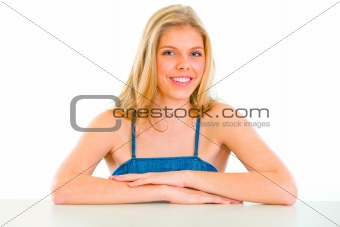 Smiling beautiful girl sitting at table 

