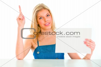 Teen girl with rised finger holding blank paper
