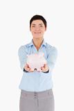 Smiling businesswoman holding a piggy bank