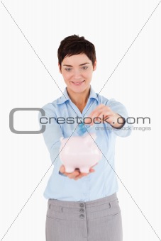 Woman putting a bank note in a piggy bank