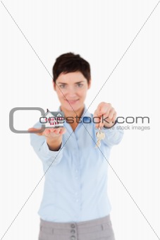 Woman showing keys and a miniature house