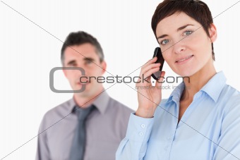 Woman telephoning while her colleague is posing