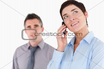 Woman making a phone call while her colleague is posing