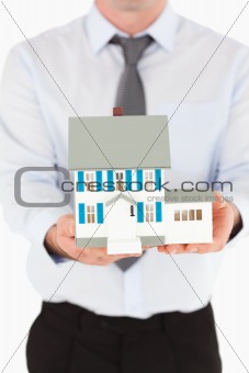Portrait of a man holding a miniature house