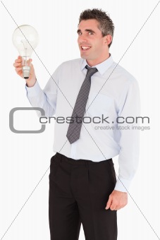 Smiling man holding a light bulb