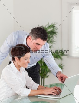 Portrait of a manager and his secretary working with a laptop