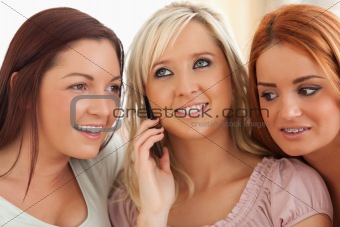 Cute women sitting on a sofa with a mobile