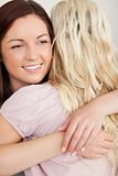 Close up of Cheerful women hugging on a sofa