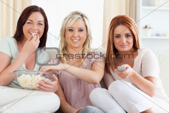 Laughing young Women watching a movie eating popcorn