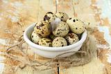 quail eggs in a bowl on a wooden table
