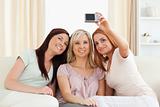 Cute women lounging on a sofa with a camera