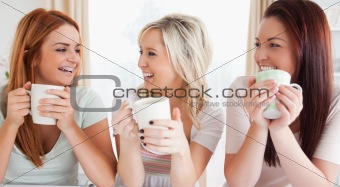 Young Women sitting at a table with cups