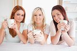Cute Women sitting at a table with cups
