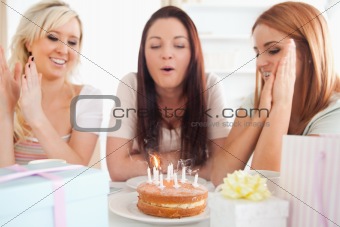 Gorgeous Women sitting at a table with a cake
