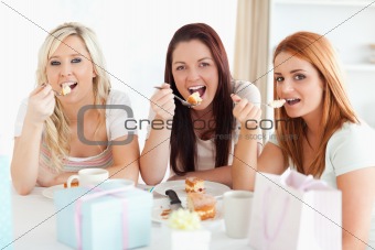 Good-looking Women sitting at a table eating a cake