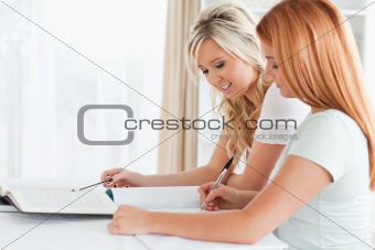 Cooperating Women sitting at a table doing their homework