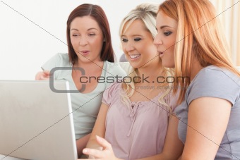 Charming women sitting on a sofa with a laptop