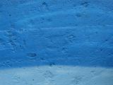 concrete wall spray painted in 2 types of blue 