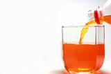 Pouring orange beverage.
