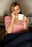 Woman Relaxing With Cup Of Coffee Watching Television