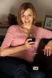 Woman Relaxing With Glass Of Wine Watching Television