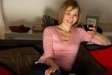 Woman Relaxing With Glass Of Wine Watching Television