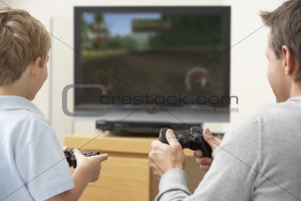 Father And Young Son Playing With Game Console