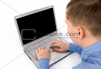 Rear view of a young man working of a laptop