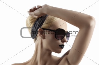 fashion shot of blond girl with sunglasses posing against white 