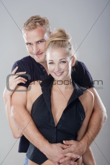 portrait of a young happy couple standing, smiling - isolated on light gray