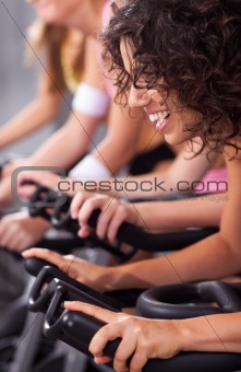 Attractive females on bicycles in a gym