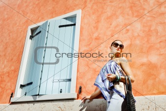 Young attractive woman near the wall with window