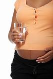 Pregnant belly with glass of water