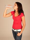 attractive young woman in red t-shirt and jeans drinking bottled